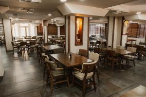 a dining room with wooden tables and chairs at Hotel Istatov in Nov Dojran