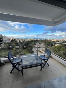 a balcony with two chairs and a glass table at Residance Panorama 52 in Sousse