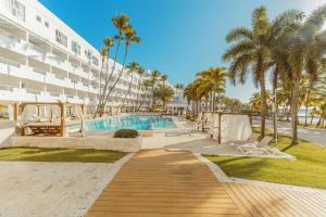 a pool at a resort with palm trees and a building at Santo Domingo Bay Convention Resort & Casino in Boca Chica
