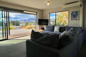 a living room with a couch and a large sliding glass door at Blue Lake Lodge - Lake Tekapo in Lake Tekapo