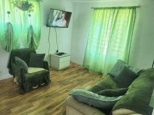 a living room with a couch and a chair at Downtown apartment next to highway netflix+wifi in Edmundston