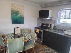 a kitchen with a table and a kitchen with a sink at Downtown apartment next to highway netflix+wifi in Edmundston