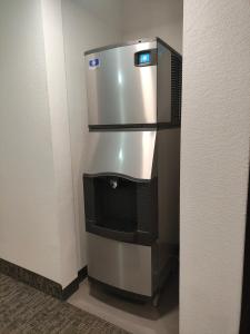 a stainless steel refrigerator in the corner of a room at The Grove Inn and Suites in Eagle Grove