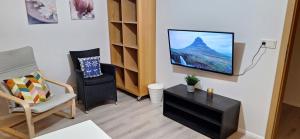 a living room with a flat screen tv on a wall at Cottage in the middle of nowhere 2 in Ölfus