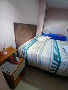 a bedroom with a bed and a nightstand next to it at Pousada Santa Maria in Canoinhas
