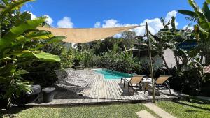 a deck with chairs and a pool in a backyard at Biribandos Rooms - a 300 metros do Quadrado e 900 metros das praias in Trancoso