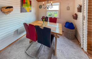 a dining room with a wooden table and red chairs at Nice Home In Broager With Wifi in Broager