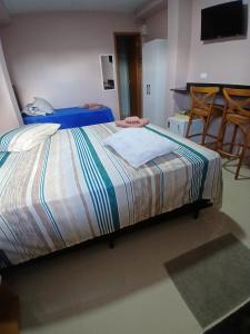 a bedroom with a bed and a table and chairs at Pousada Santa Maria in Canoinhas +10 photos