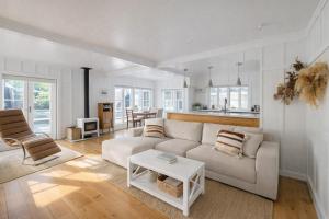 a living room with a couch and a table at Raglan West Cottage, Surf Side Escape in Raglan