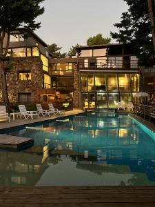 a large swimming pool in front of a building at Village de las Pampas Apart Hotel Boutique in Mar de las Pampas