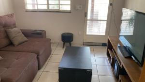 a living room with a couch and a flat screen tv at Casa Versátil in Ribeirão Preto