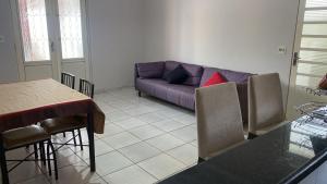 a living room with a purple couch and a table at Casa Versátil in Ribeirão Preto
