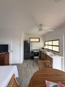 a living room with a kitchen and a dining table at Tuava - Mirimiri Lodge in Ataiti +20 photos