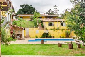 a yellow house with a swimming pool in a yard at Chácara lar e paz Mairinque in Mairinque