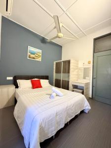 a bedroom with a large bed with a red pillow on it at Ipoh Garden 4BR 10Pax in Ipoh
