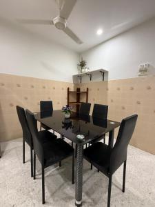 a dining room with a black table and black chairs at Ipoh Garden 4BR 10Pax in Ipoh