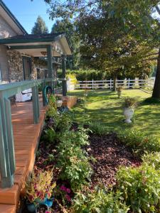 a garden with a wooden deck and flowers at Lake Room in Sandpoint