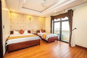a bedroom with two beds and a large window at Ks sơn trang 1 in Sầm Sơn