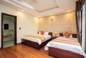 a hotel room with two beds and a bathroom at Ks sơn trang 1 in Sầm Sơn