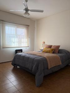 a bedroom with a large bed with a ceiling fan at Casa amplia 3 dormitorios, 2 baños - Smart TV 50" - Entrada Autónoma - Pileta de Verano in Mendoza