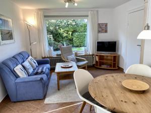 a living room with a blue couch and a table at Lerchenweg Bungalow in Westerland