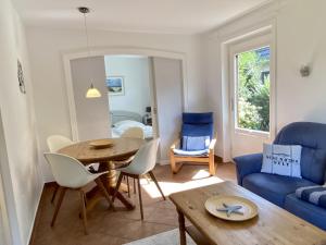 a living room with a table and a blue couch at Lerchenweg Bungalow in Westerland