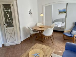 a living room with a table and chairs and a bed at Lerchenweg Bungalow in Westerland