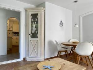 a room with a door and a table and chairs at Lerchenweg Bungalow in Westerland +12 photos