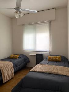 a bedroom with two beds and a window at Casa amplia 3 dormitorios, 2 baños - Smart TV 50" - Entrada Autónoma - Pileta de Verano in Mendoza
