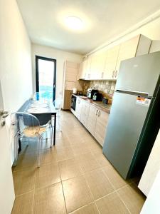 a kitchen with a refrigerator and a table in it at DAV apart in Otopeni +12 photos
