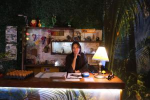 a woman sitting at a desk with a lamp at Prisamata in Salta