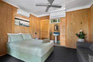 a bedroom with a large white bed and a bathroom at Dolphins Backpackers in Sunshine Beach