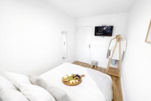 a white room with a white couch and a bowl of fruit at CC Room Gaia in Vila Nova de Gaia