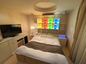 a small room with a bed and a television at HOTEL Le Grand in Matsuzaka
