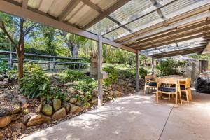 a patio with a table and chairs under a roof at Bendalong - Rural Retreat, Short Drive to CBD in Orange