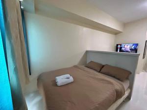 a bedroom with a bed with a white towel on it at Sweden's Tiny Home, Studio Unit Condo in Manila