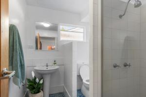 a white bathroom with a sink and a toilet at Dolphins Backpackers in Sunshine Beach +20 photos