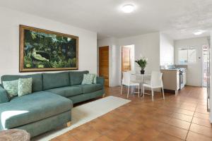 a living room with a green couch and a table at Dolphins Backpackers in Sunshine Beach