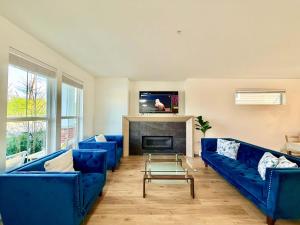 a living room with blue couches and a fireplace at Luxury 3Br Oasis Gated Yard Pets Welcome in Langley
