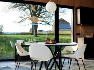 a dining room with a table and chairs and a large window at Modern design house with sauna 'Arduenna Silva' in La-Roche-en-Ardenne