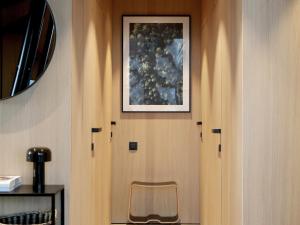 a door with a chair and a picture on the wall at Modern design house with sauna 'Arduenna Silva' in La-Roche-en-Ardenne