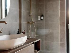 a bathroom with a white sink and a shower at Modern design house with sauna 'Arduenna Silva' in La-Roche-en-Ardenne +33 photos