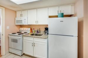 a kitchen with white cabinets and a white refrigerator at Direct Oceanfront Unit Amazing Views with Pools in Myrtle Beach