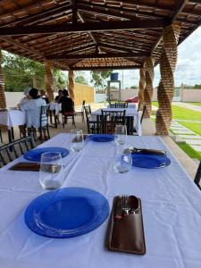 a table with blue plates and wine glasses on it at Chalés Brisas dos lençóis in Barreirinhas