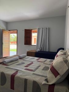 a bedroom with a large bed and a window at Chalés Brisas dos lençóis in Barreirinhas