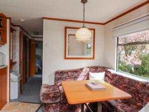 a living room with a couch and a table at Fron Dderw Caravan in Holyhead