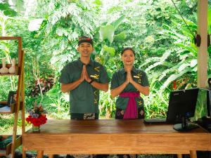 a man and a woman standing in front of a table with their hands in praying at Kaura Manggis, Bali - Luxury Tent in Candidasa