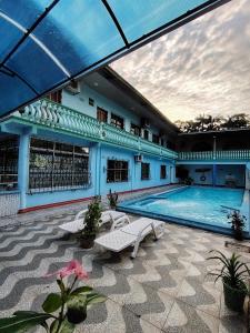 a large swimming pool with two lounge chairs and a building at Hotel Alto Amazonas in Leticia