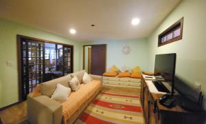 a living room with a couch and a flat screen tv at Casa Limoeiro in Petrópolis