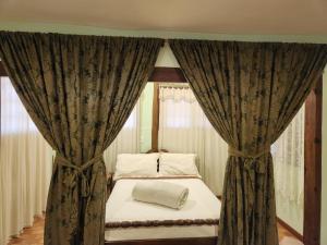 a bedroom with a bed with curtains in a room at Casa Limoeiro in Petrópolis